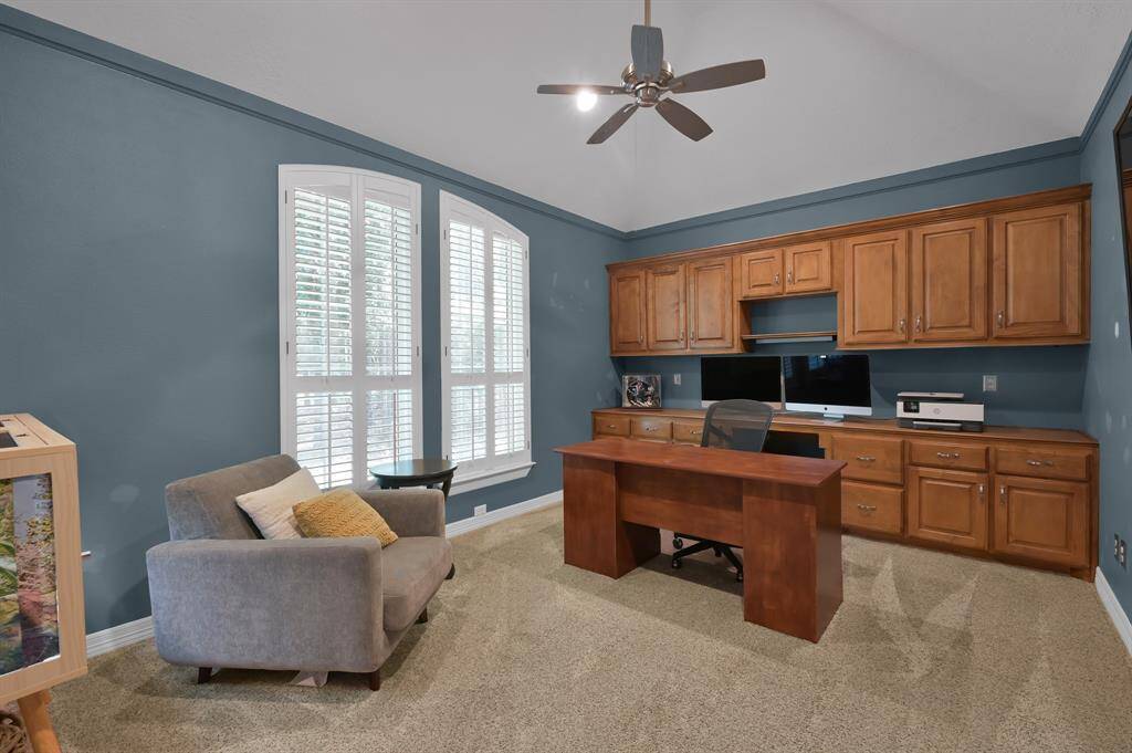 The spacious study is outfitted with custom built in cabinetry