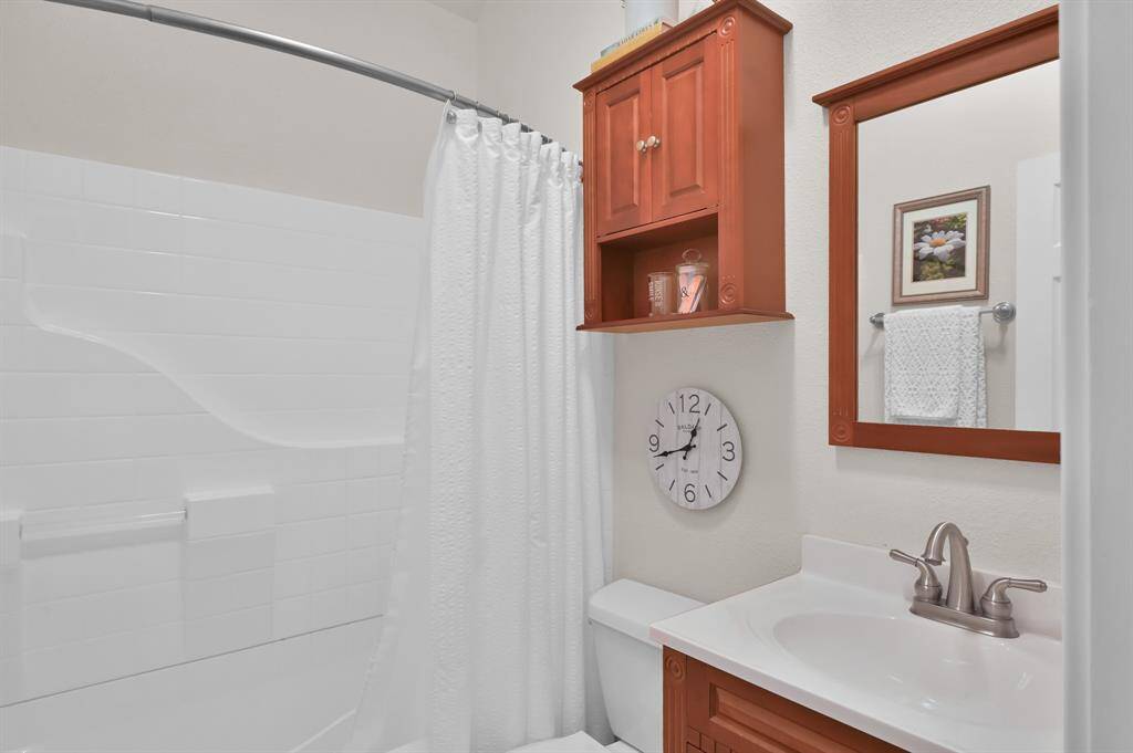 The full bathroom in the garage apartment features a shower/tub and vanity area