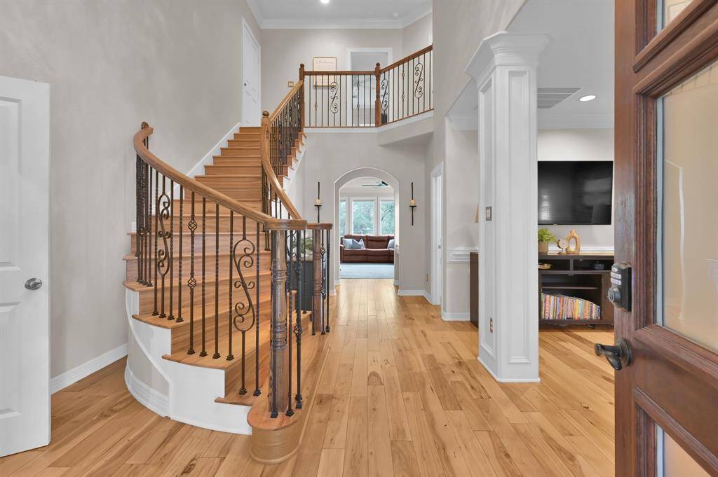 Tall ceilings, custom wood and iron spiral staircase, oversized wood flooring and so much more greet you as you enter the home