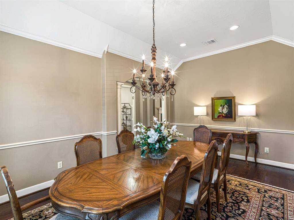 Columns flanking the entry and a delicate archway elevate the room’s graceful design, while 5-inch baseboards, crown molding, and a timeless chair rail add sophisticated finishing touches, making it the perfect space for both formal and casual dining.