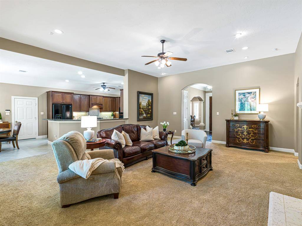 The spacious family room creates a cozy, inviting atmosphere with soft, plush carpet, complemented by 5-inch baseboards and recessed lighting that set a warm, welcoming ambiance.
