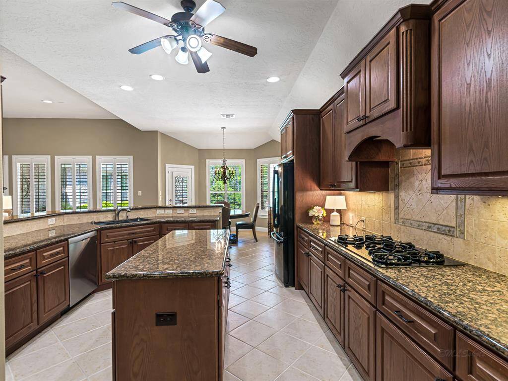 Under-cabinet lighting and recessed ceiling lights provide both task and ambient lighting, while a ceiling fan adds comfort.  The kitchen also features beautiful 42-inch solid wood cabinets adorned with crown molding for a polished finish.