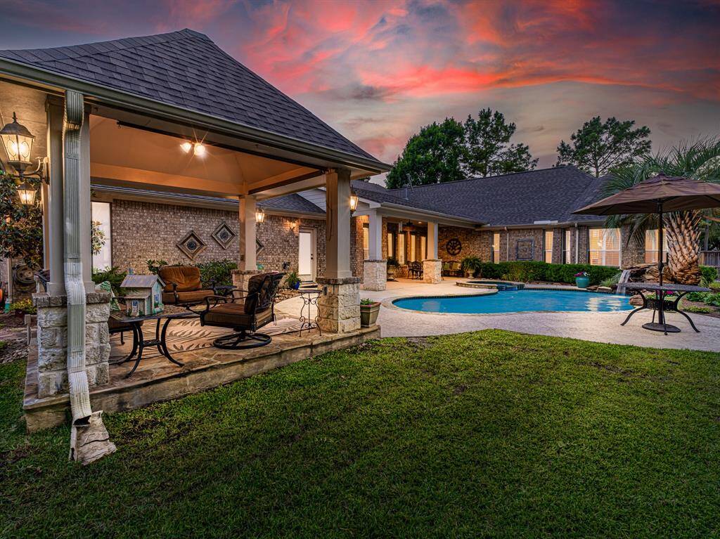 This outdoor oasis features a sparkling pool and spa, a covered patio for shaded relaxation, a charming gazebo with roller shades, and plenty of patio space for lounging or entertaining guests.