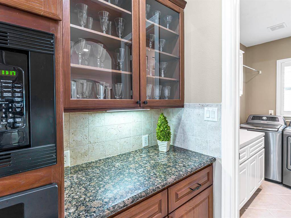 A convenient butler’s pantry includes two banks of crystal display cabinets, ideal for showcasing glassware or collectibles.