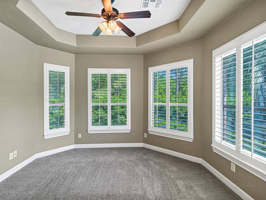 A large and versatile sitting area, framed by four additional windows also fitted with plantation shutters, provides the perfect space for reading, relaxing, a private workspace, or a nursery.