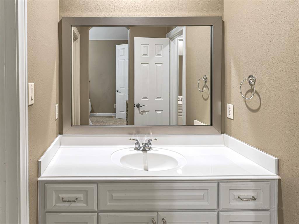 The Jack and Jill bathroom features a vanity with crisp white cabinetry, six drawers, brushed nickel finishes, and recessed lighting. A tub/shower combo with a frosted glass window completes the space with both function and privacy.