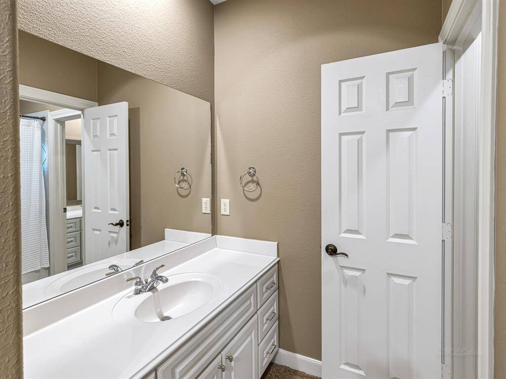 The Jack and Jill bathroom features a vanity with crisp white cabinetry, six drawers, brushed nickel finishes, and recessed lighting. A tub/shower combo with a frosted glass window completes the space with both function and privacy.