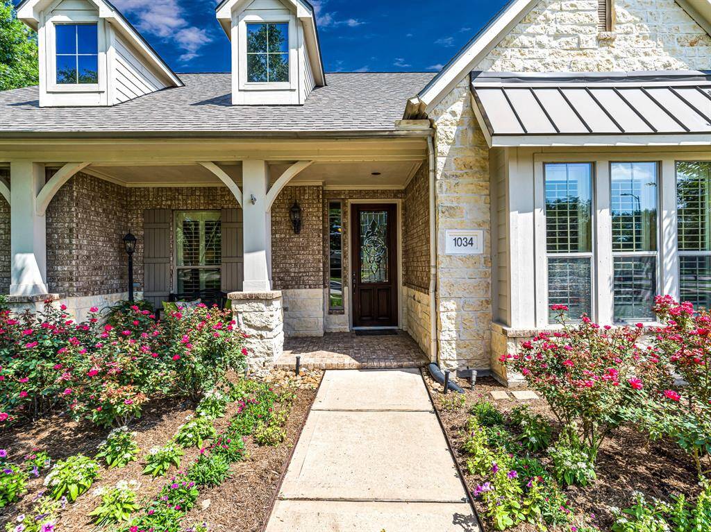 From the moment you arrive, you'll be welcomed by exceptional curb appeal, featuring a classic brick and stone elevation, a spacious covered front porch, and lush, well-maintained landscaping.