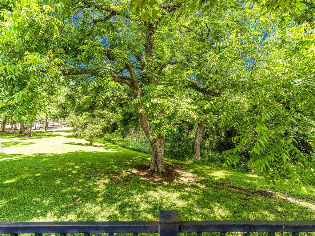 Beyond the iron gate at the back of the property, enjoy peaceful views of a serene greenbelt, offering privacy and tranquility behind the home.