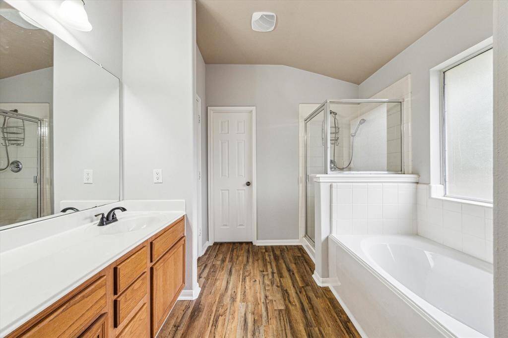 Primary bath has a deep soaking tub and separate walk-in shower and new flooring.