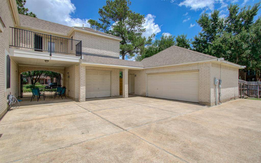 Rearview Of house with porte-cache 3 car garage with golf cart entrance between the drive way and enough back yard for your recreational camper. See separate Mom Suite above the single care garage with her private balcony