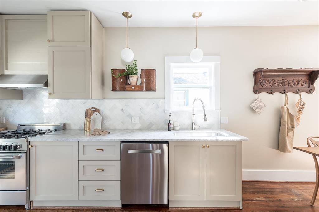 Timeless design meets functionality with shaker-style cabinetry, Carrera marble surfaces, and brass hardware—all anchored by premium stainless steel appliances.