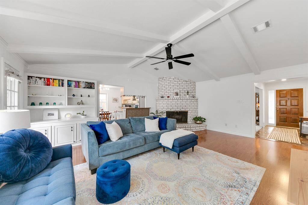 The room is bright and airy, with an open layout leading to the dining area. Hardwood floors and modern furnishings complete the inviting look.