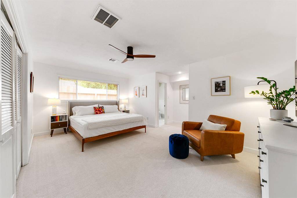 Spacious primary bedroom with wood-like laminate flooring and a private en suite bath