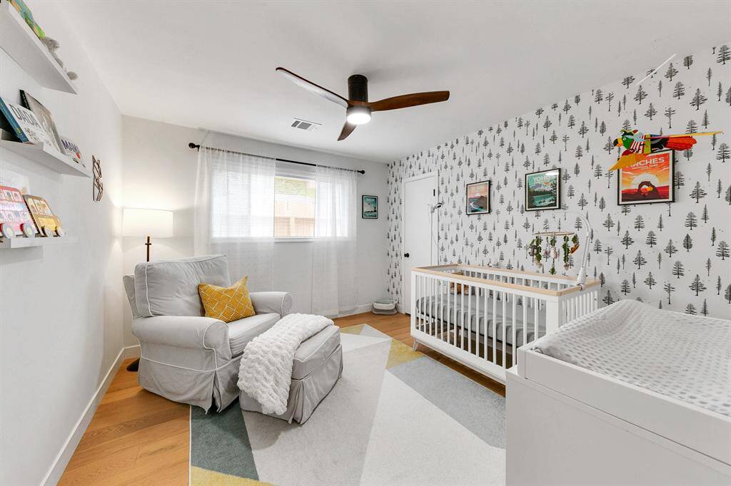 Comfortable secondary bedroom with wood-like laminate flooring, neutral walls, and flexible space for guests, office, or hobbies.