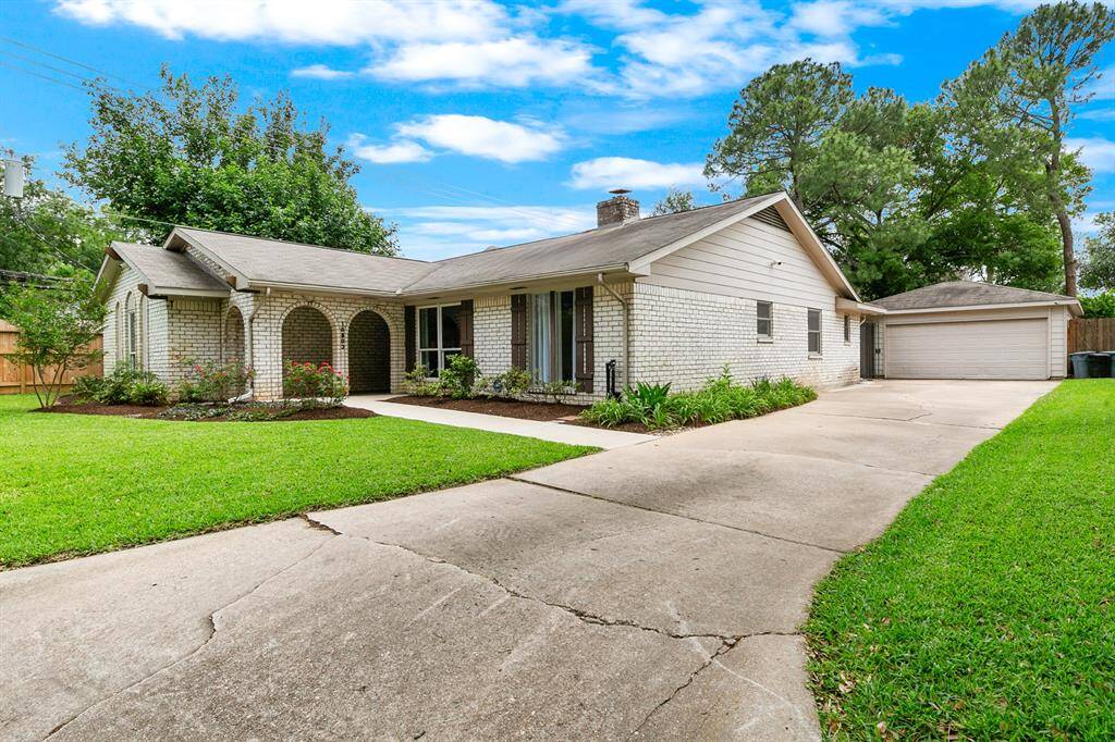 This charming one-story home features a classic brick exterior, a spacious driveway, and a well-maintained front yard with lush greenery. The arched entrance adds character, and the detached garage offers additional storage space. Ideal for buyers seeking a cozy and inviting property.