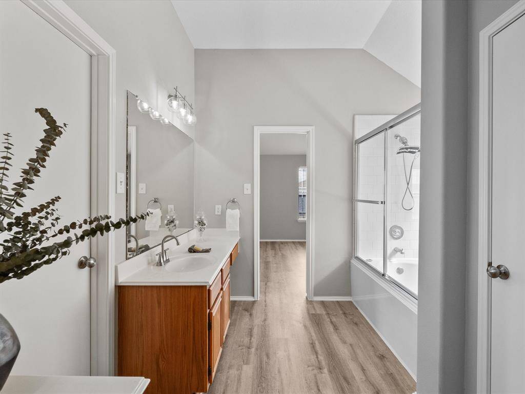 This galley primary bathroom has a huge linen closet on the right and a spacious walk in closet.