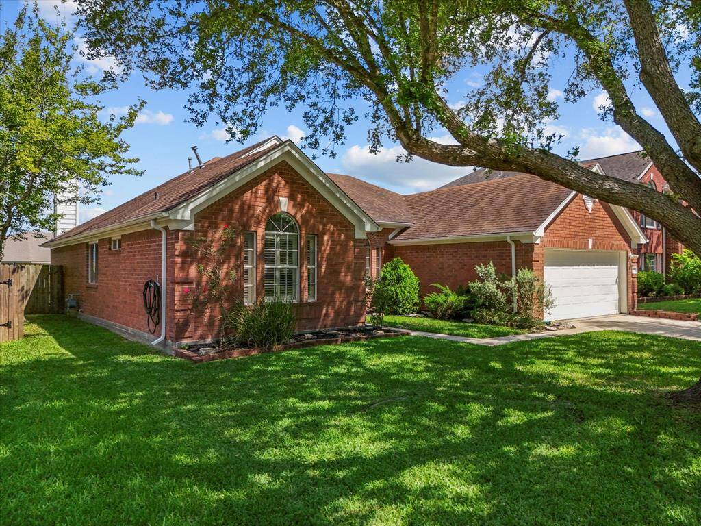 It includes a two-car garage and a welcoming entrance, offering great curb appeal in a suburban neighborhood.