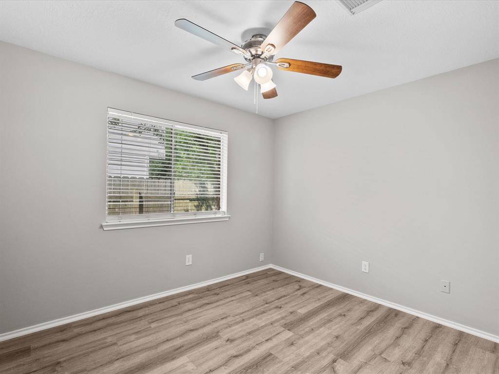 Third bedroom with small window and ceiling fan.