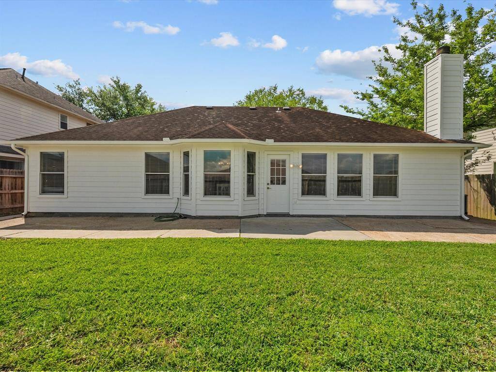 The back view of the home highlights the bay window, and the concrete patio that extends the full width of the home!