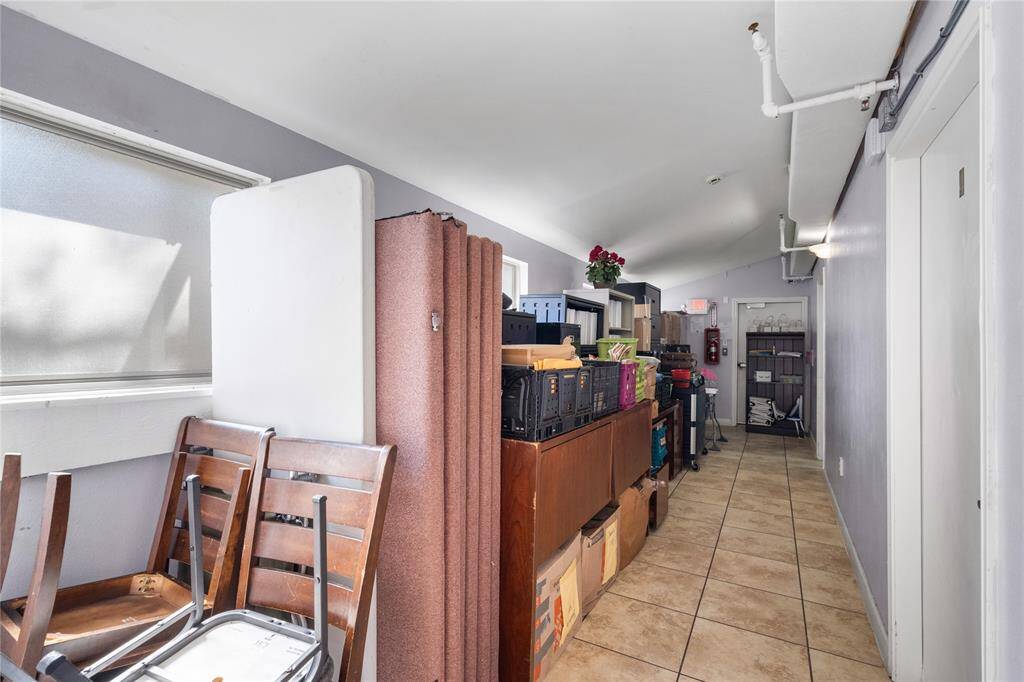 This long, narrow hallway with gray walls and a neutral tile floor can be used for many things! Whether you want to use this space for storage, or to display your work, or have tables lined up in this area-your options are endless.