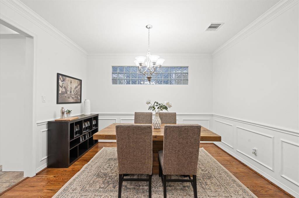 Classic Elegance, Modern Touches. With wainscoting details, a chandelier that sets the perfect mood, and a stylish glass block window that lets in the light just right, this dining space is the ultimate blend of sophistication and comfort.