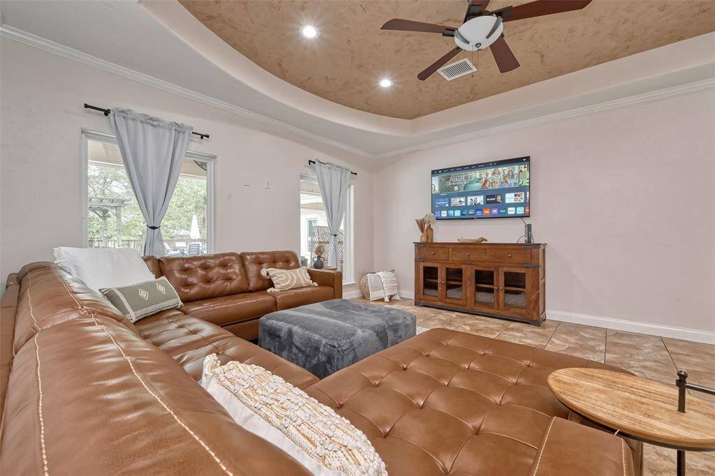 Entertainment-ready living space includes a mounted smart TV, natural light, and direct access to the backyard retreat.