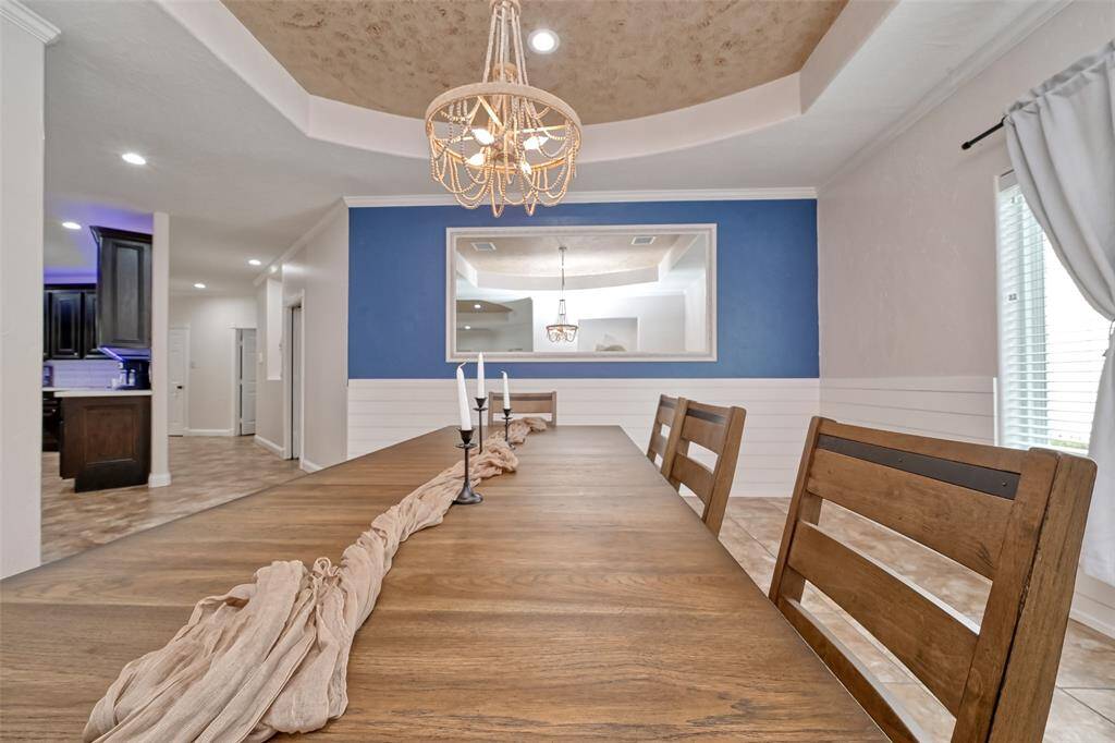 Dining Room Toward Kitchen – Perspective shot showing the elegant dining setup leading into the kitchen, capturing the luxurious ceiling design and continuity of flow.