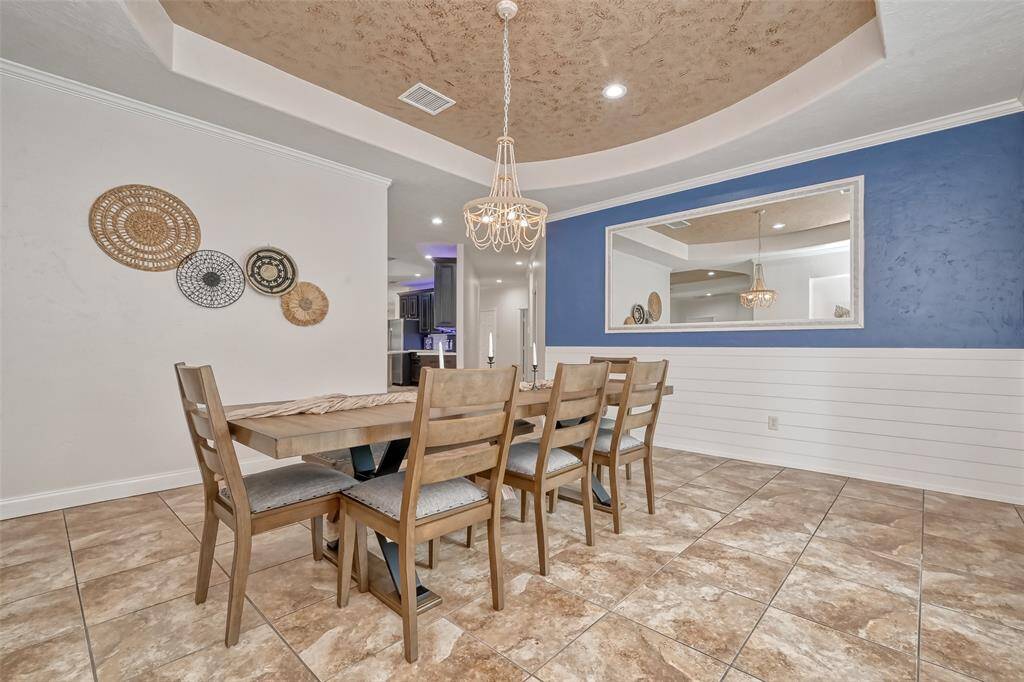 Dining Room with Wall Decor – Full view of the dining room from another angle, showcasing neutral tones, textured ceiling, and charming woven wall art for added character.