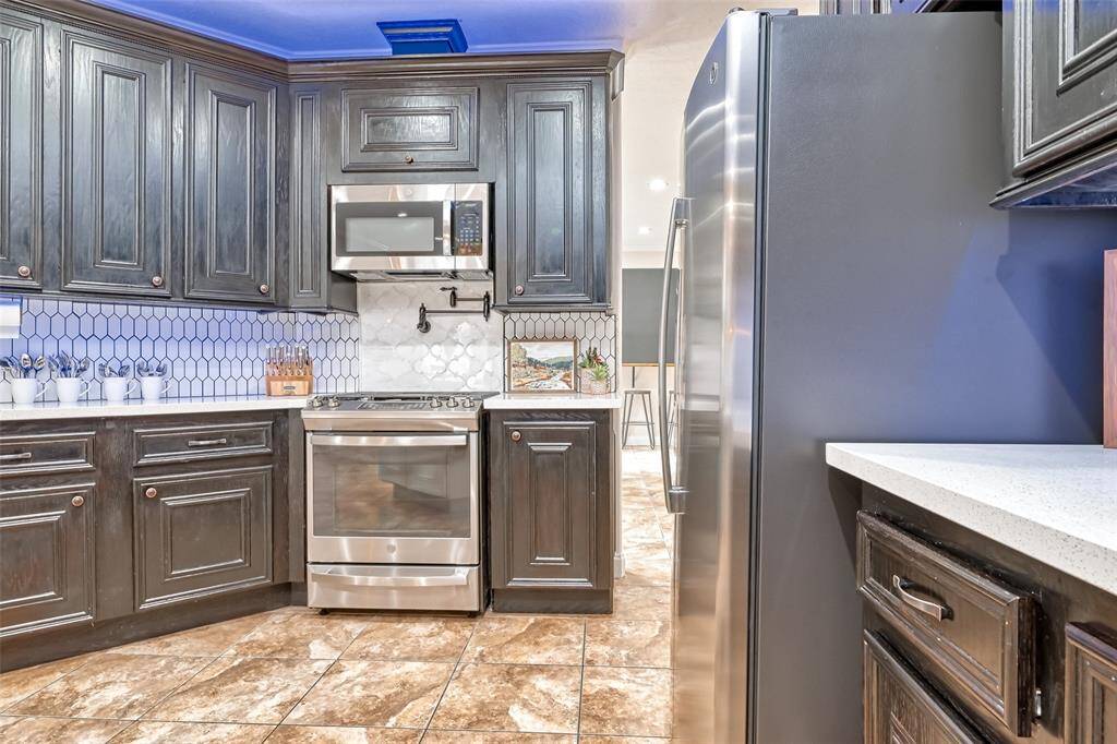 The kitchen offers a seamless stainless steel appliance package and a cozy coffee nook, perfect for morning routines or late-night snacks.