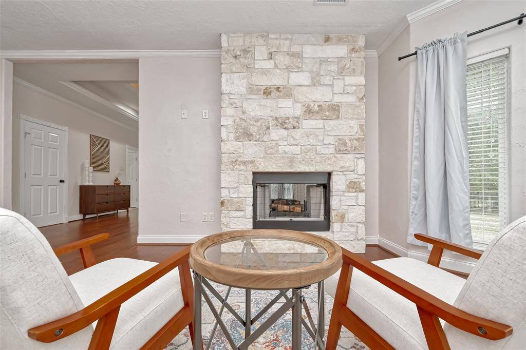 Enjoy fireside chats in this elegant sitting nook, perfectly framed by stonework and bright natural light.