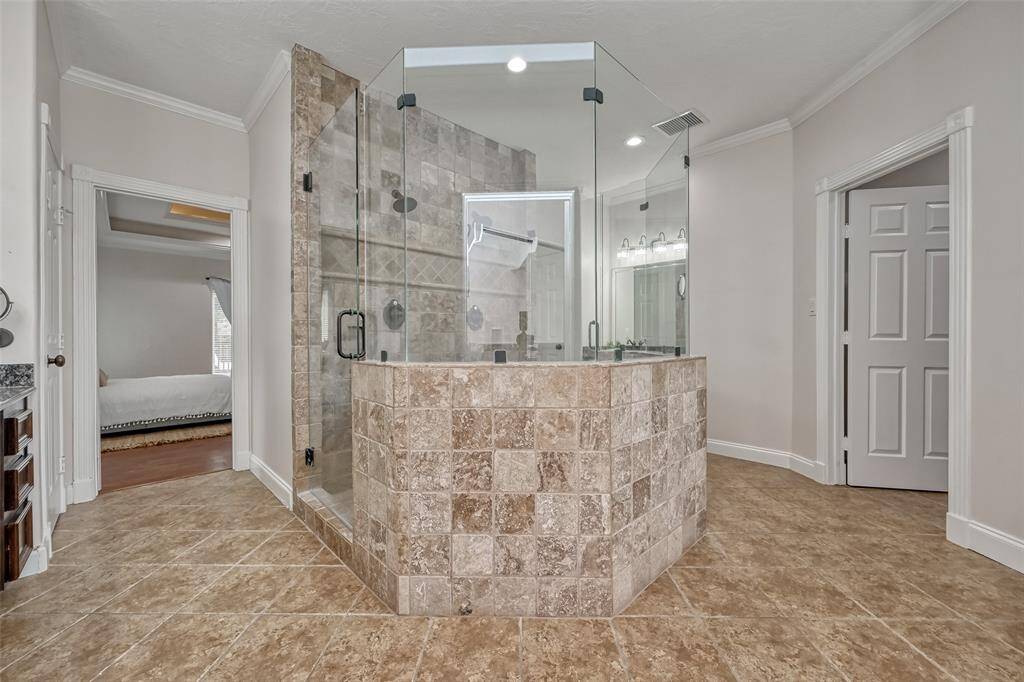 Step into luxury with a grand walk-in shower, featuring a stunning tile surround and sleek glass enclosure.