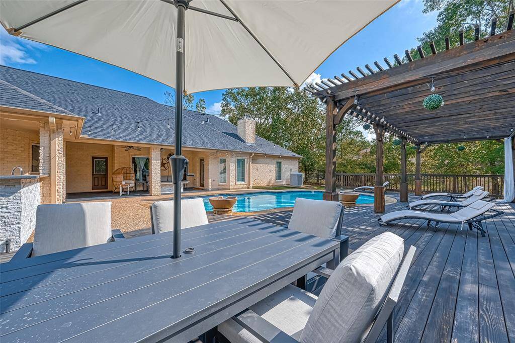 Backyard Oasis – With loungers, a pergola, and poolside dining, this deck is built for fun and relaxation.