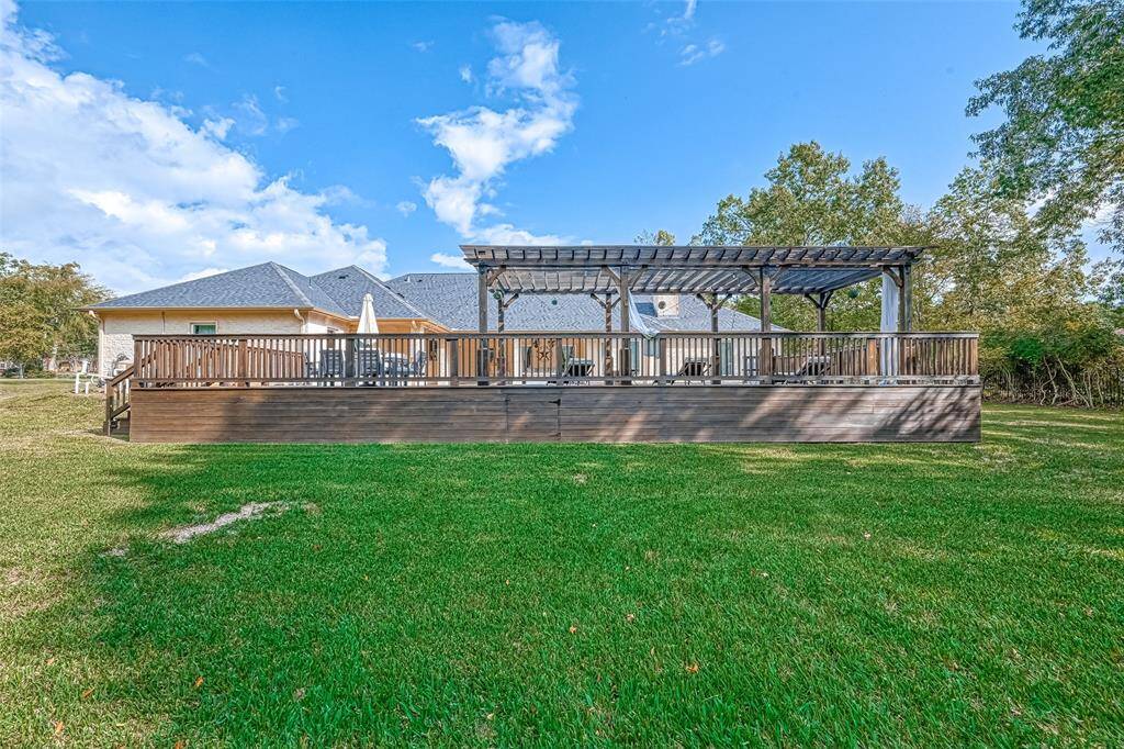Expansive Backyard Oasis -This elevated deck and lush green yard offer endless space for play, relaxation, and outdoor entertaining.