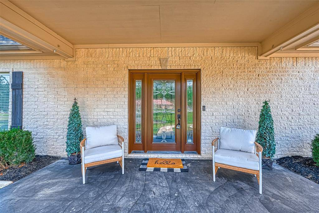 Detailed front entry showcases a beautiful glass-paneled door flanked by tall windows, creating a warm and inviting entrance.