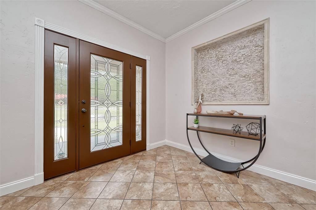 Stylish entryway with decorative tile flooring and a textured wall niche offers a warm welcome the moment you step inside.