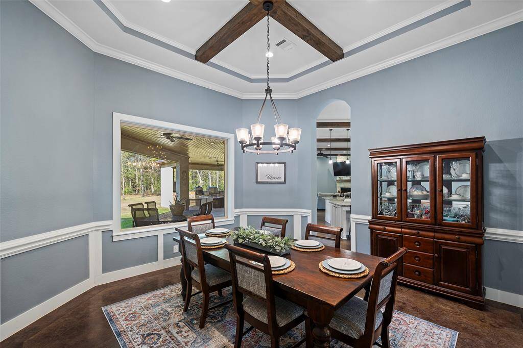Notice the tray ceilings with wood beams , chair railing and beautiful chandelier.