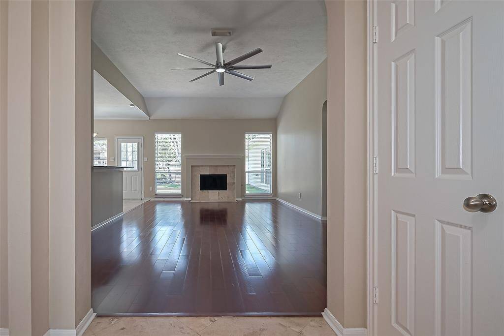 Spacious Family Room w/Wood Flooring, fireplace, great for entertaining. This view is from the front door entry
