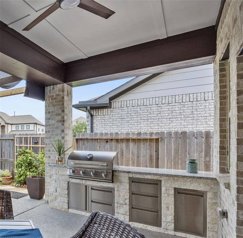 What a great addition! A built-in grill and granite countertop with storage and trash areas as well.