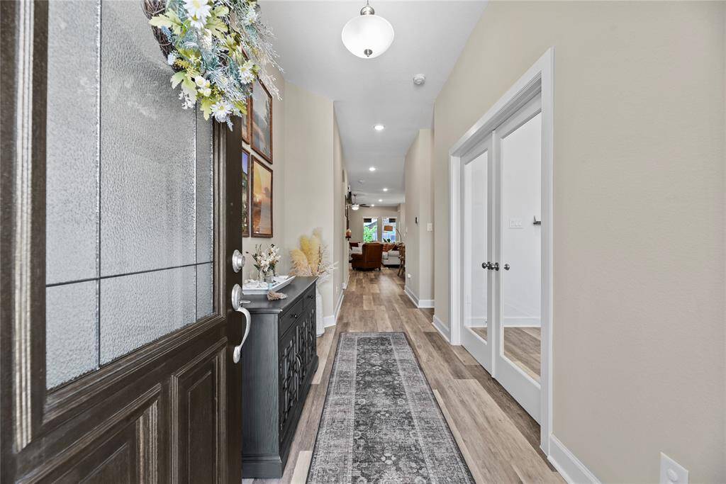 Welcome to a bright and inviting entryway that leads to the grand hallway that showcases trending flooring and French doors on the right add a touch of sophistication to the private office or flex space at the front of the home.