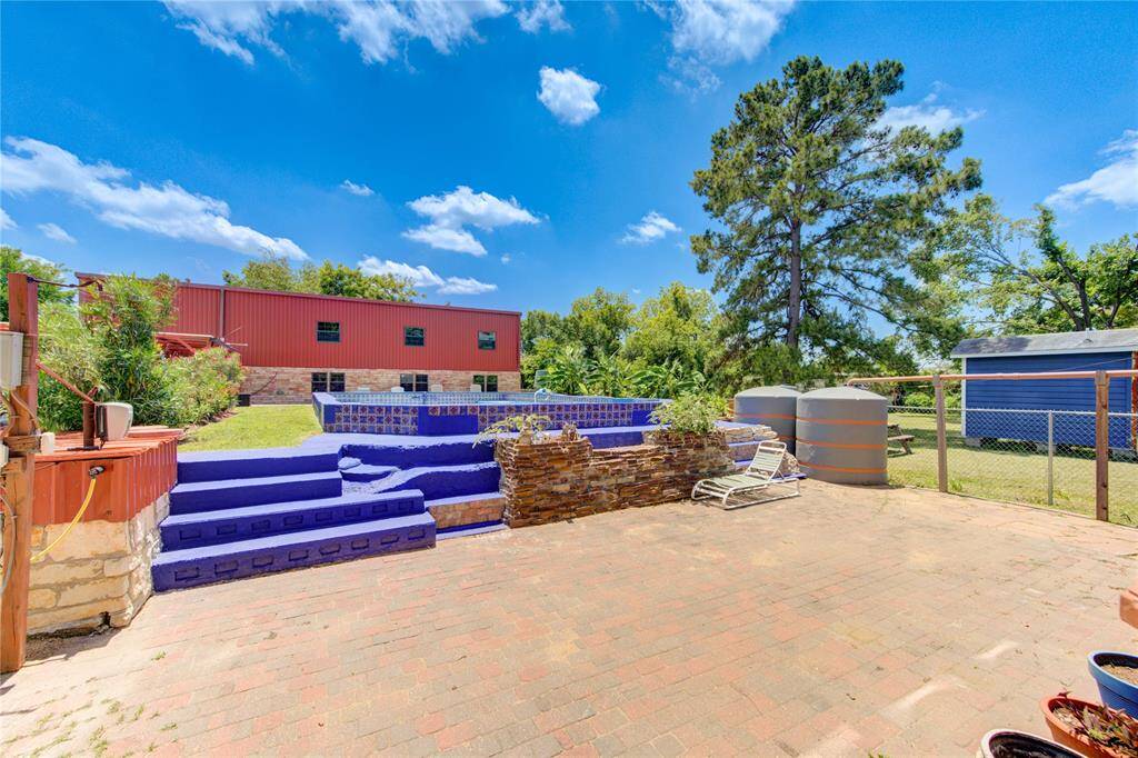 Steps & pool deck are painted with a no slip paint. Back patio is ready for grilling and entertaining. Two of 6 barrels used to harvest rain are located at end of pool.