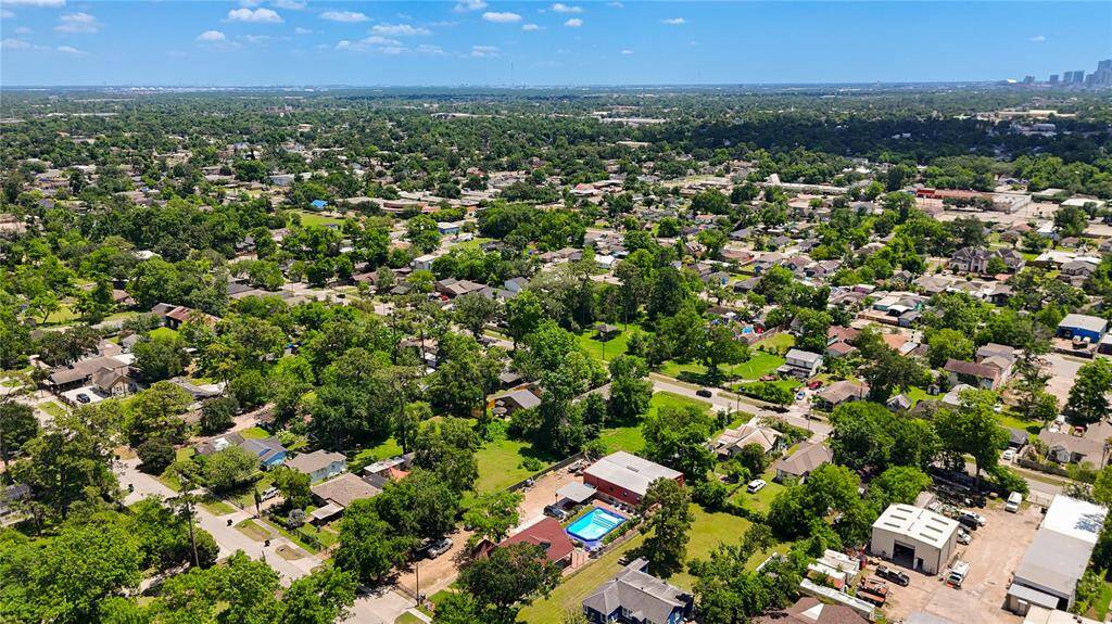 Aerial shot of property and its exceptional parking capacity for a business. Surrounding neighborhood and Houston in top right corner also shown.