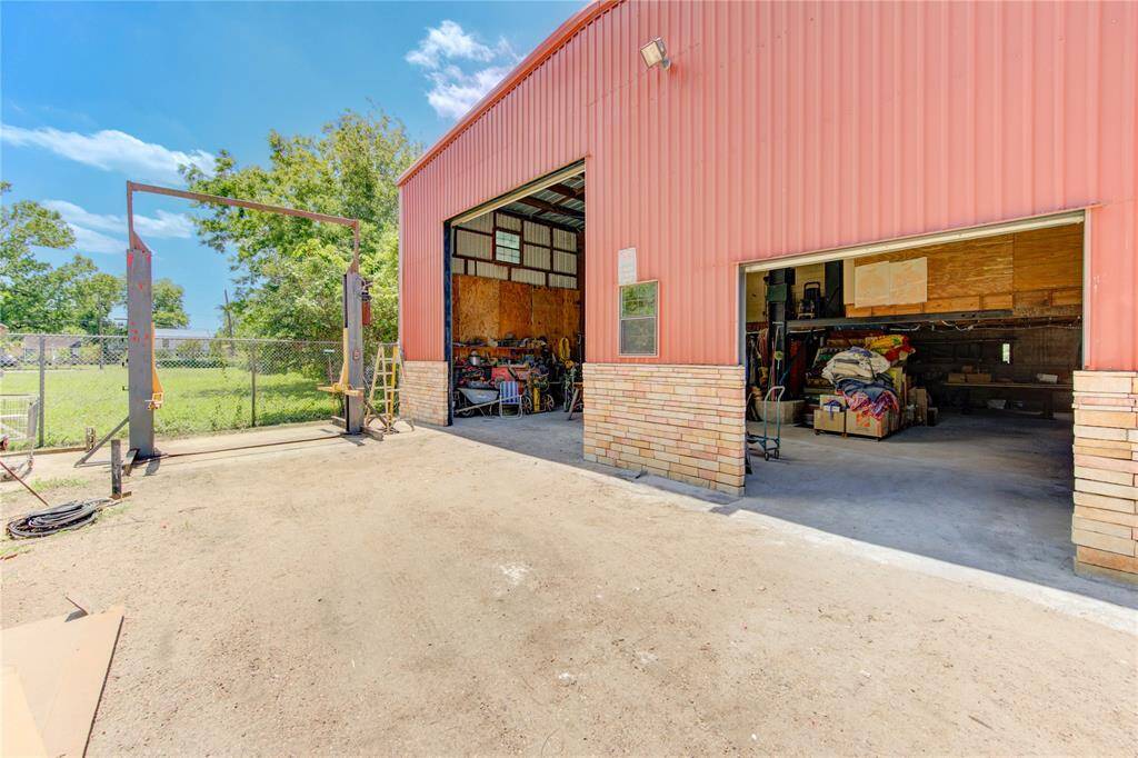 Multi car garage/workshop. 7,000 lb. car lift to stay and two large overhead garage doors. Smaller has remote control door opener