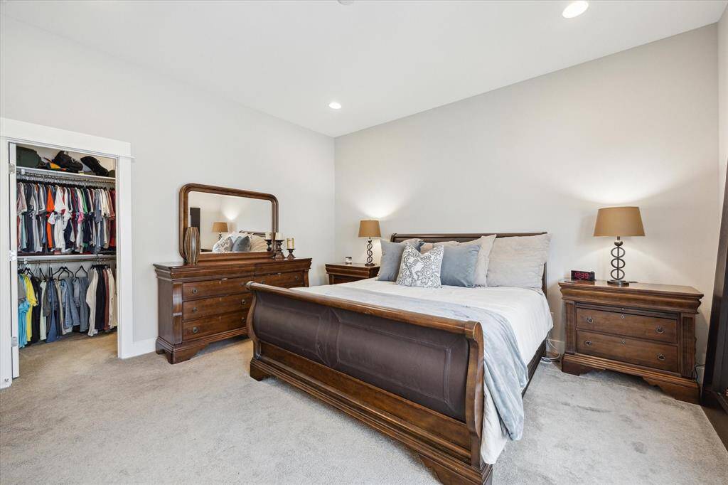 The spacious primary bedroom features a cozy carpeted floor and a convenient walk-in closet for ample storage.