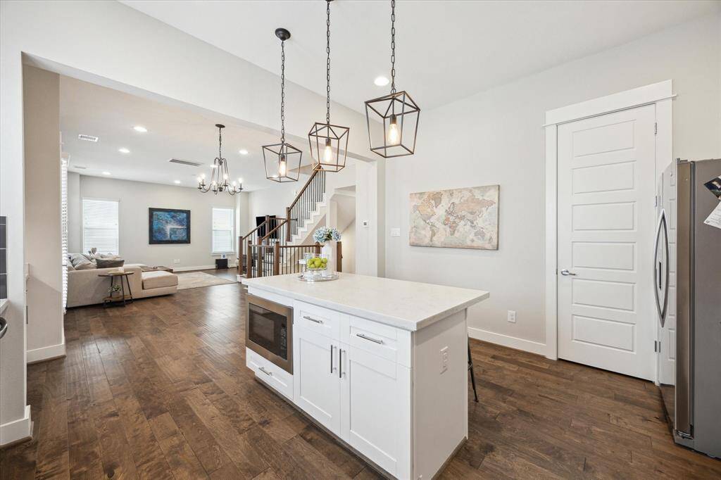 A spacious, bright bedroom with neutral tones gets ample natural light from the two windows. Cozy and inviting atmosphere.