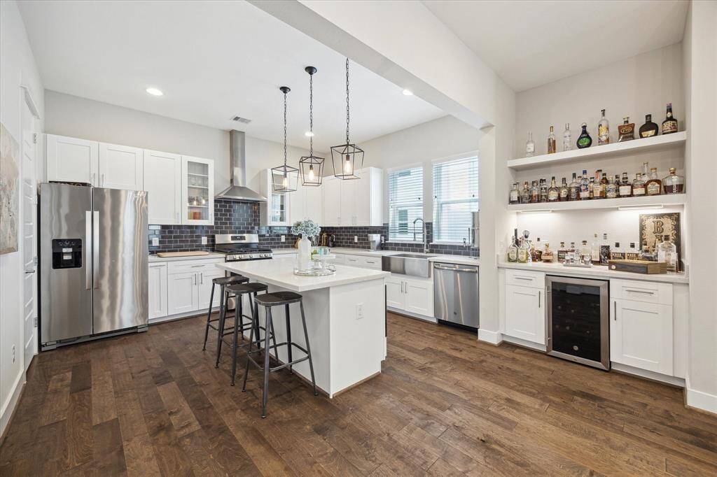 This kitchen features a spacious island near the stunning dry bar, a perfect spot to entertain.