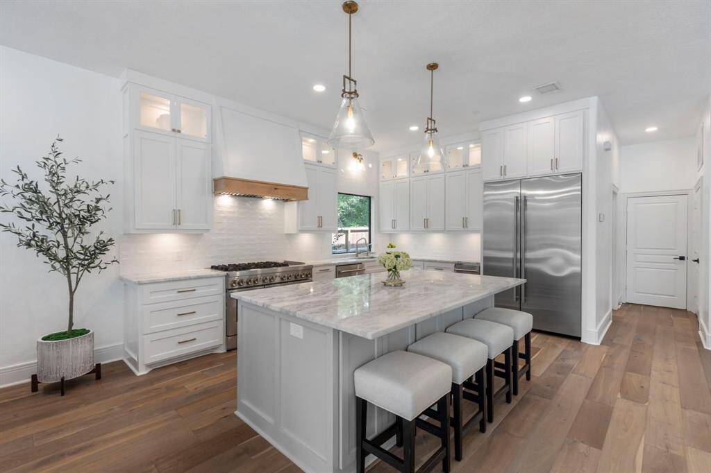 With over $70,000 of renovations in October of 2023 - this sleek and modern fully remodeled kitchen is both stunning and highly functional. Anchored by an oversized island with quartzite countertops, ample seating, and built-in storage, the space is perfect for entertaining and everyday living.