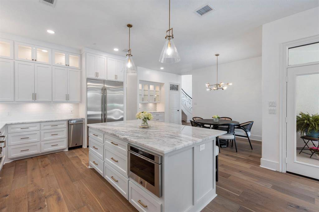 Jenn Air luxury appliances include a 48” French door refrigerator, drawer microwave in the island, and a small cube ice maker. The Karastan engineered wood flooring add warmth and richness, tying this luxurious space together beautifully.