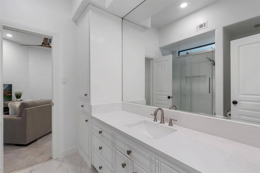 Secondary bedroom #1 has access to a full remodeled bath with quartz counters, elegant tile floors and shower/tub combination with glass enclosure.  The bathroom is also conveniently located near the game room.