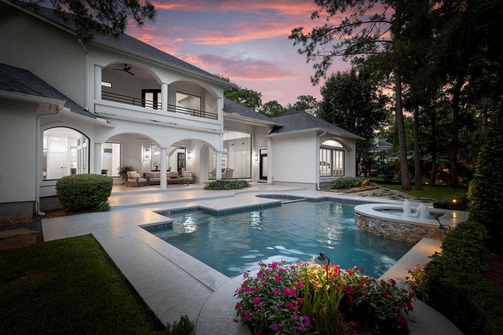 An expansive deck with a covered patio provides ample space for outdoor entertaining, while a mosquito misting system ensures year-round comfort.